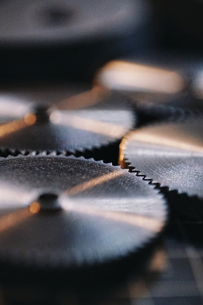 about-02 Detailed view of silver metallic gears in an industrial environment, showcasing precision and engineering.